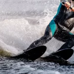 close-up man athlete riding waterskiing on lake, extreme summer water sports
