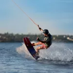 Teenage boy wakeboarding on river. Extreme water sport