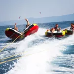 Group of four bouncing up over wake on tubes on Croatian coast